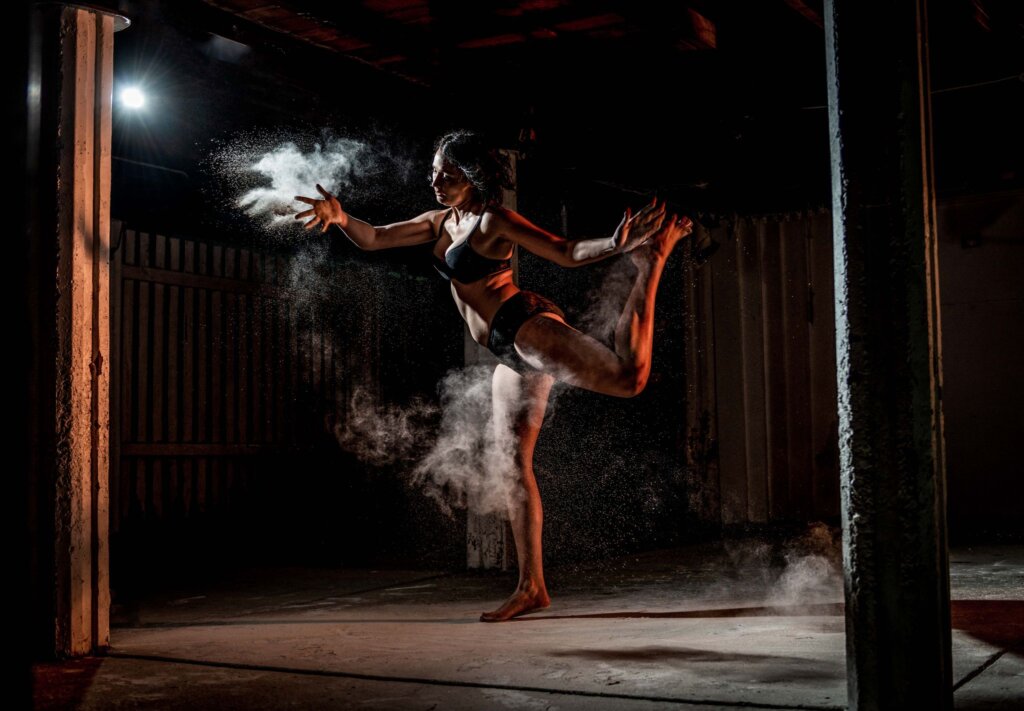 Dancer surrounded in white powder mid-air action shot