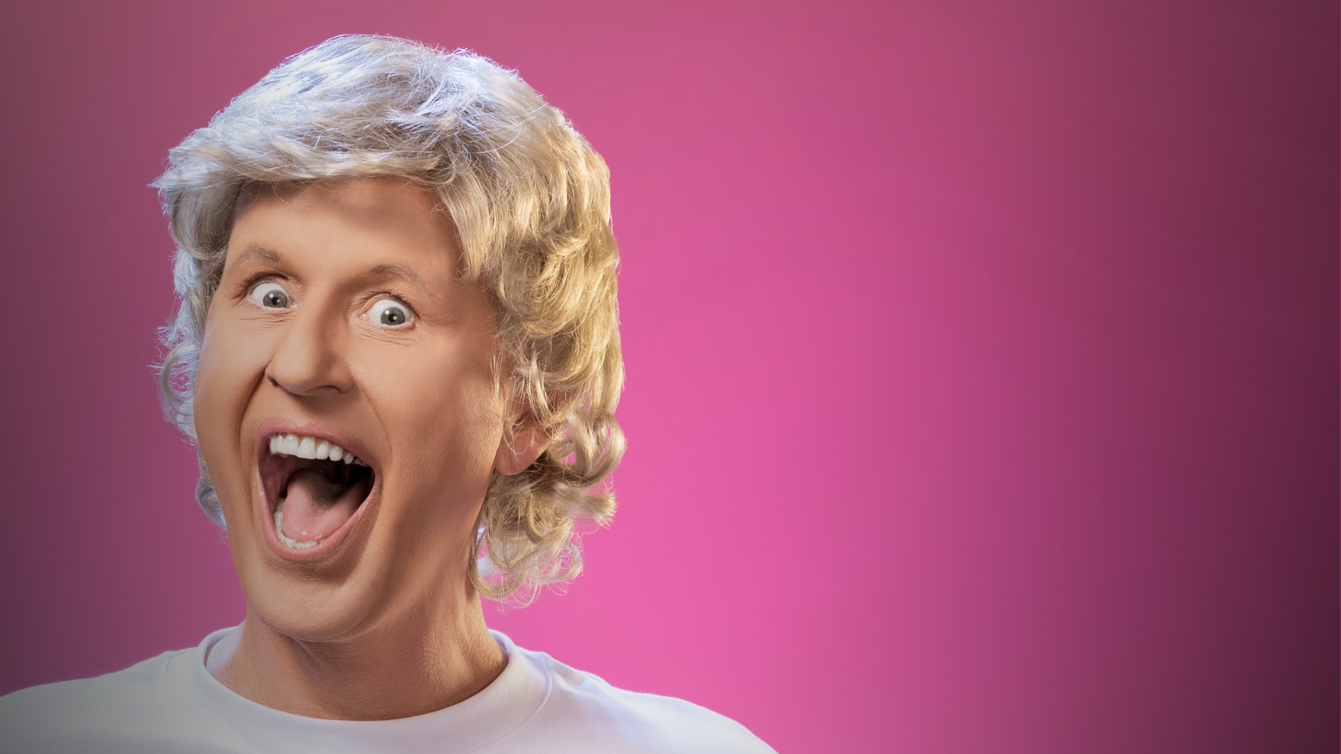 A person with a blonde curly wig smiles broadly with an open mouth against a bright pink background, wearing a white shirt—a fitting image for the vibrant Bob Downe Brisbane Comedy Festival 2025 at the Powerhouse.