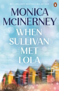 Book cover for When Sullivan Met Lola by Monica McInerney, showing colorful seaside huts at the bottom and a blurred blue sky with white bokeh effect.