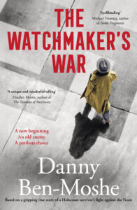 A person in a yellow coat and hat walks on a shadowed pavement; red text reads The Watchmakers War by Danny Ben-Moshe, a novel about a Holocaust survivors fight against the Nazis.